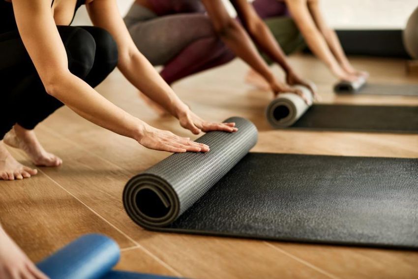 Vier Frauen rollen ihre Yoga-Matten auf